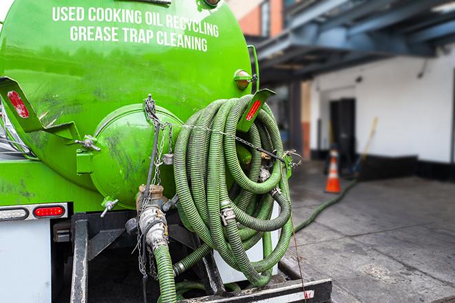 a technician pumping a grease trap in a commercial building in Hamtramck, MI